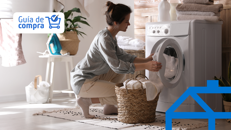 Mujer joven sacando la ropa de la lavadora en casa