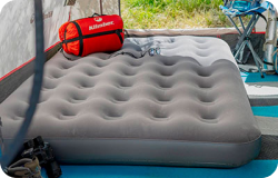 Colchón inflado al interior de una carpa del especial camping y automóvil