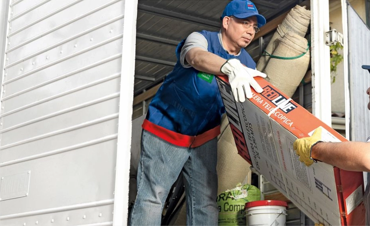 Trabajador descargando un camión con un producto, en el despacho que es uno de los tipos de entrega.