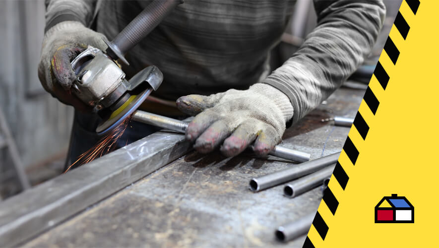 Primer plano de manos con implementos de seguridad que manejan una herramienta profesional de corte en metal
