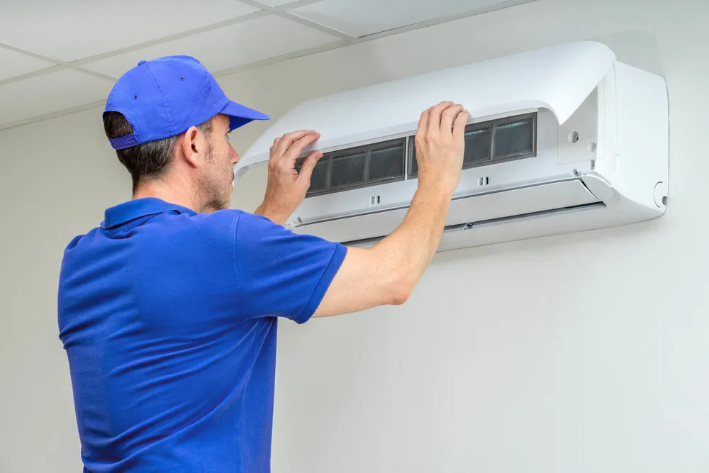 Técnico instalando filtro em um dos tipos de ar-condicionado Split para garantir o funcionamento ideal.