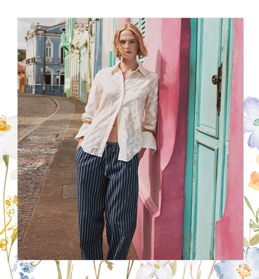 Modelo con blusa blanca y pantalón a rayas azules